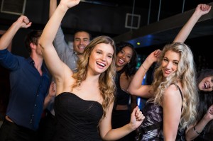 Happy friends dancing together in a nightclub